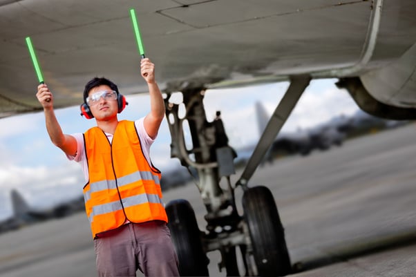 Air traffic controller holding light signs at the airport