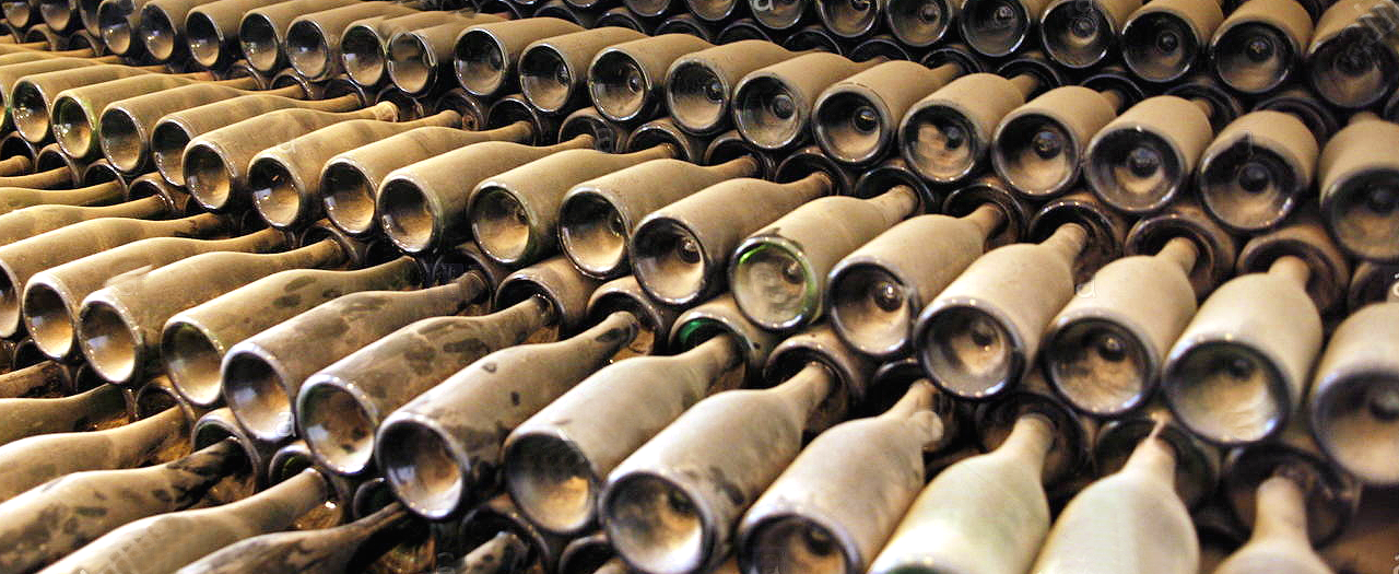 full-frame-shot-of-dust-covered-wine-bottles-in-warehouse-WK0N8B